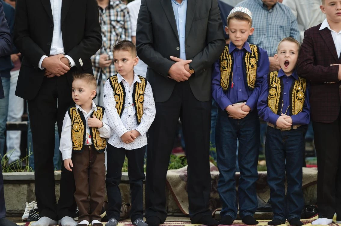 Young Kosovo Muslims attend the Eid al-Fitr prayer near the Sulltan Mehmet Fatih mosque in Pristina on June 25, 2017. Eid al-Fitr festival marks the end of the holy Muslim fasting month of Ramadan during which devotees are required to abstain from food, drink and sex from dawn to dusk. / AFP / Armend NIMANI