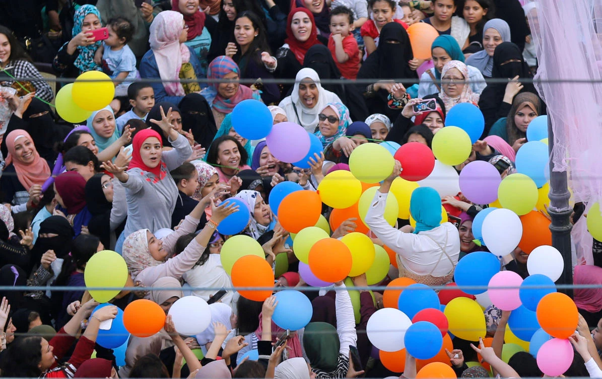 Egyptians celebrate and try to catch balloons released after Eid al-Fitr prayers, marking the end of the Muslim holy fasting month of Ramadan at a public park, outside El-Seddik Mosque in Cairo, Egypt June 25, 2017. REUTERS/Amr Abdallah Dalsh