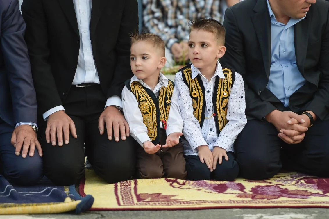 Young Kosovo Muslims attend the Eid al-Fitr prayer near the Sulltan Mehmet Fatih mosque in Pristina on June 25, 2017. Eid al-Fitr festival marks the end of the holy Muslim fasting month of Ramadan during which devotees are required to abstain from food, drink and sex from dawn to dusk. / AFP / Armend NIMANI