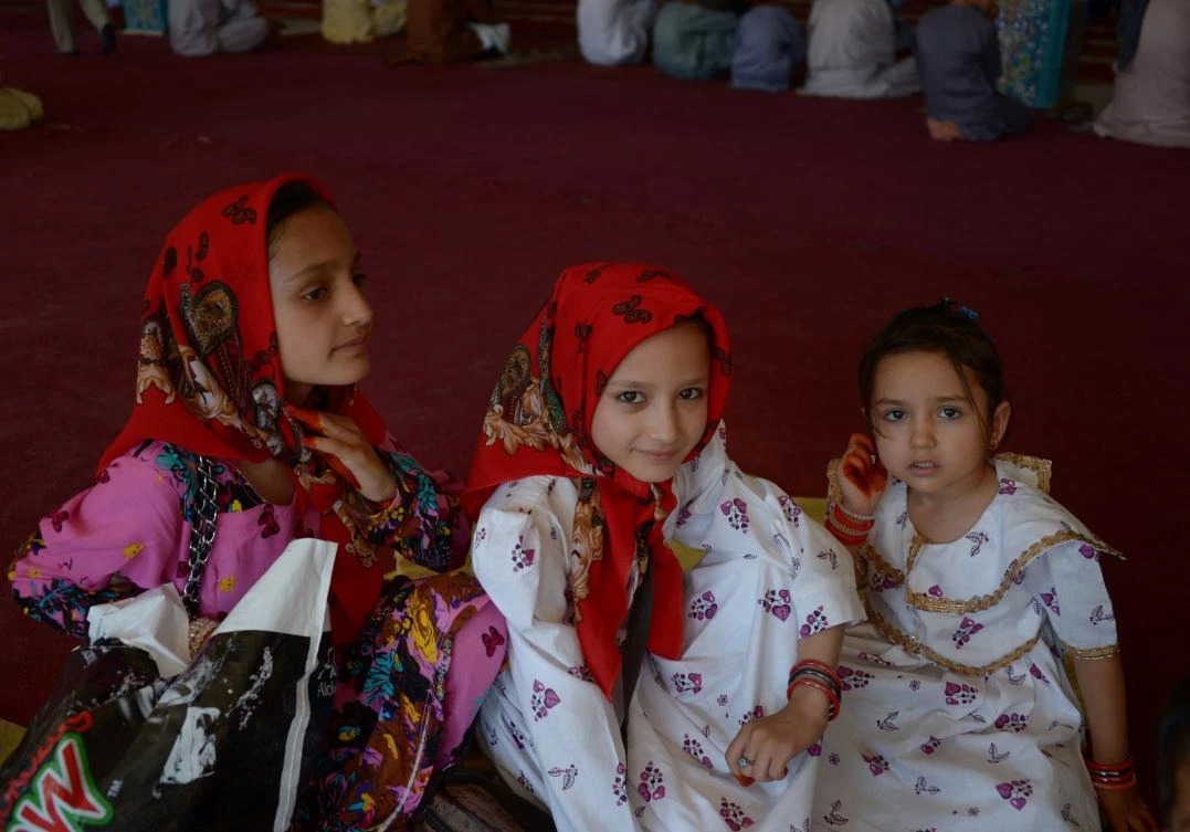 Afghan children look on during Eid al-Fitr prayers in the courtyard of Hazrat Ali shrine, or Blue Mosque, in Mazar-i-Sharif on June 25, 2017. / AFP / Farshad USYAN