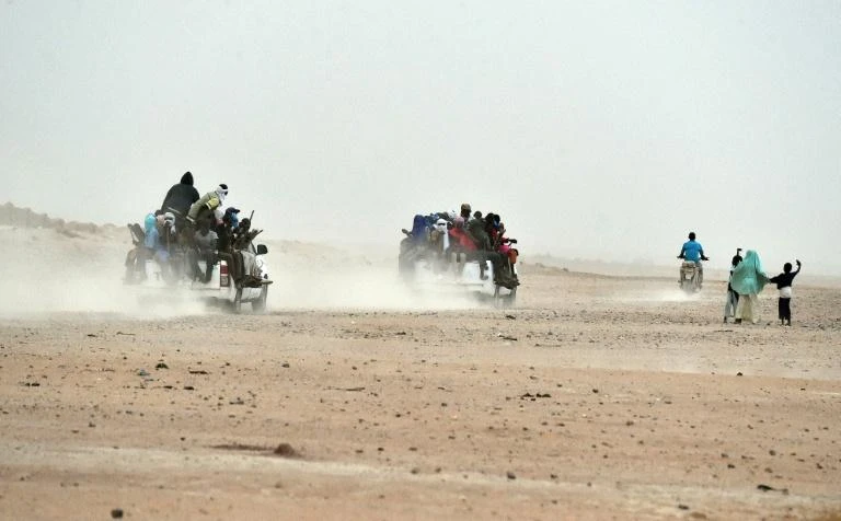 Migrants on pick-up trucks leave the outskirts of Agadez, Niger, heading across the Niger desert towards Libya and, ultimately, Europe. (AFP)