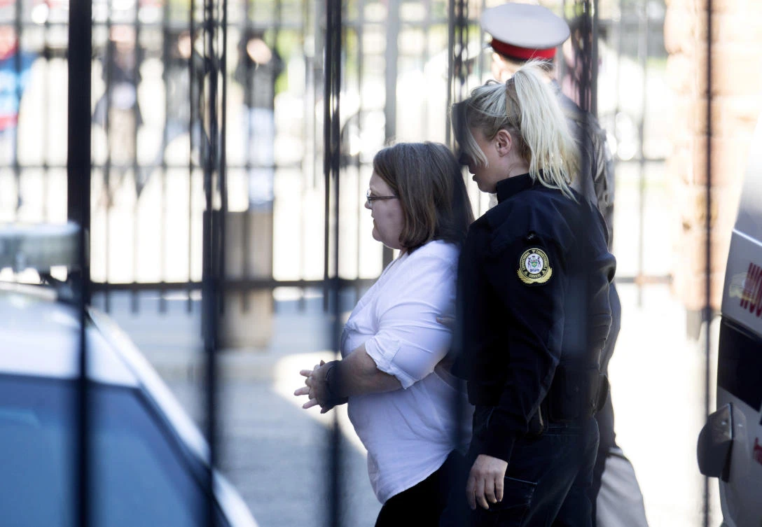 Elizabeth Wettlaufer is escorted into the Provincial courthouse in Woodstock, Ontario. (Peter Power/The Canadian Press via AP)