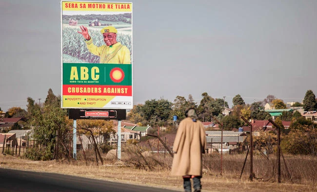 A man walks past an electoral poster of Lesotho’s former Prime Minister Tom Thabane in Maseru, Lesotho on Thursday. (AFP)