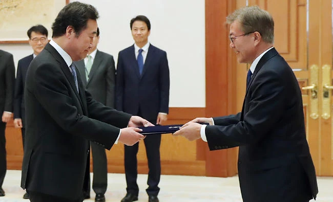 South Korea’s President Moon Jae-in, right, hands a document to new Prime Minister Lee Nak-yon during an appointment ceremony at the presidential house in Seoul. (AFP)