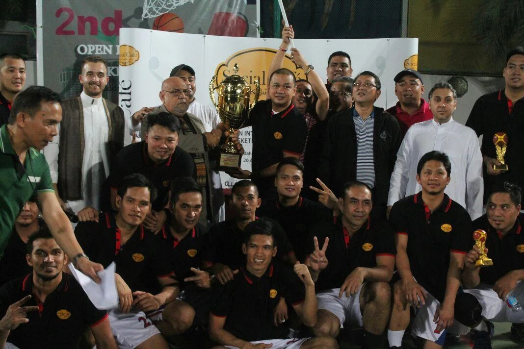 Pilipinas-Social Cafe coach Francis Magat receives the champion trophy from Mohamed Bayoumi and Mohammad Shobain. Partly hidden is team sponsor Abdullah Al-Zahrani.