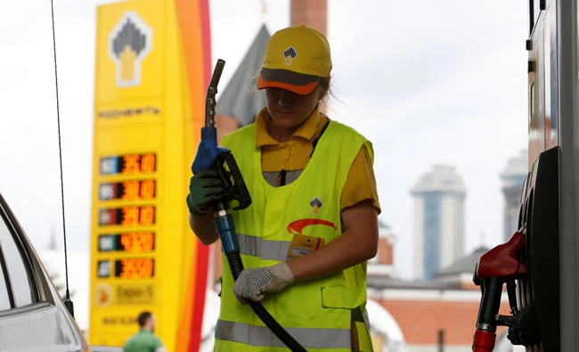An employee holds a fuel nozzle at a Rosneft petrol station, with a mosque seen in the background, in Moscow, Russia, July 4, 2016. (REUTERS File Photo)