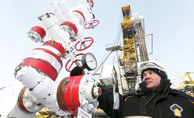A worker checks a pressure gauge at an oil pumping station owned by Rosneft in the Suzunskoye oil field in Russia. (Reuters)