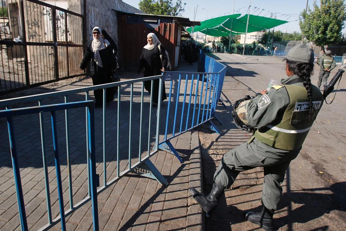 Palestinians walk through an Israeli checkpoint between the West Bank town of Bethlehem and Jerusalem as they head to Jerusalem’s Al-Aqsa Mosque compound for the first Friday prayers of the Muslim holy month of Ramadan. (AFP)