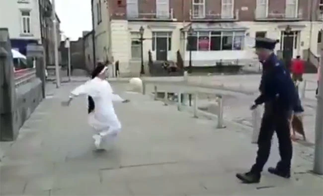 An Irish nun and a cop play football in this still image from a video shared on social media.