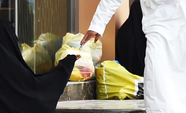 A Saudi man hands money to a woman begging outside a supermarket on a main street in the Saudi capital Riyadh, in this June 20, 2016 file photo. (AFP)