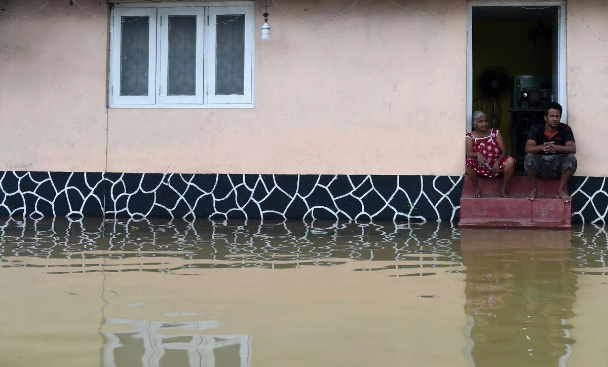 Sri Lankan residents look on through floodwaters in Kaduwela. (AFP)