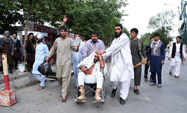 Afghan relatives push the wheelchair of a wounded man outside an Italian aid organization's hospital in Kabula on Saturday following a series of explosions that targeted a funeral of a politician's son, who was killed during an anti-government protest a day earlier. (AFP)