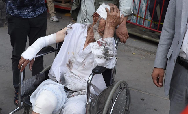 A wounded Afghan man sits on a wheelchair after receiving treatment at an Italian aid organization hospital in Kabul on Saturday following a series of explosions that targeted a funeral of a politician's son, who was killed during an anti-government protest a day earlier. (AFP / WAKIL KOHSAR)