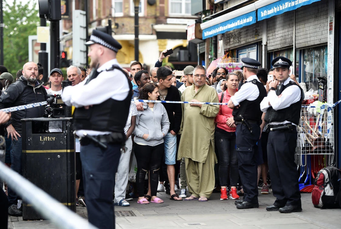 Onlookers stand at the police cordon as police search a property in Barking Road, east London, June 4, 2017. REUTERS/Hannah McKay