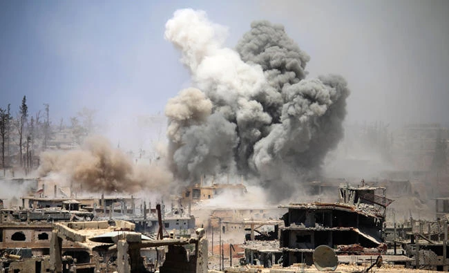 Smoke rises from buildings following a reported air strike on a rebel-held area in the southern Syrian city of Daraa on May 22, 2017. Assad forces pounded the opposition-held city again on Sunday. (AFP / Mohamad Abazeed)