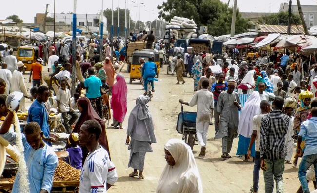 People walk among stalls at the Monday Market in Maiduguri on May 26, 2017. Torrential rains and wind destroyed 1,000 makeshift homes in northeast Nigeria over the weekend, aggravating conditions for the thousands of people displaced by Boko Haram violence, the United Nations said. (AFP / AMINU ABUBAKAR)