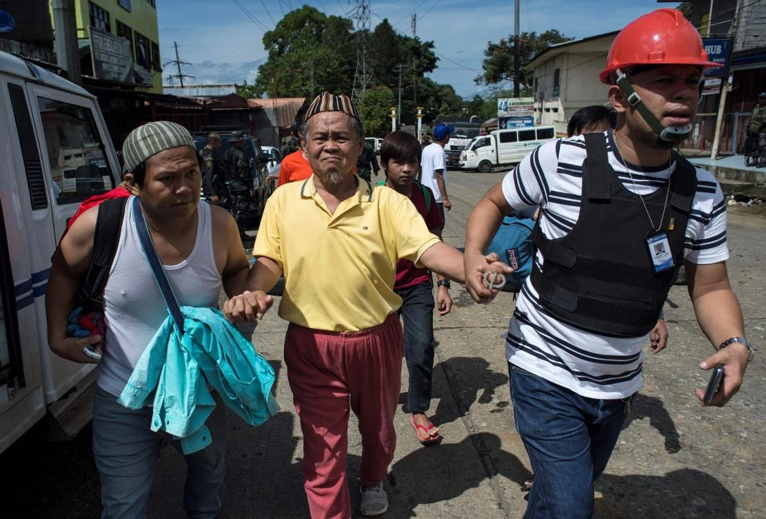 Evacuated residents arrive at a checkpoint in Marawi City on the southern island of Mindanao on Sunday. (AFP)