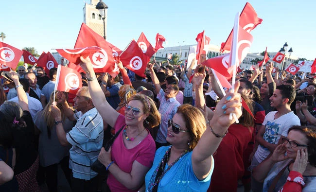 Tunisians hold flags during a recent demonstration in solidarity with Prime Minister Youssef Chahed in his fight against corruption. (AFP)