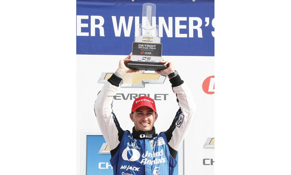 Graham Rahal raises the trophy after winning the first race of the IndyCar Detroit Grand Prix auto racing doubleheader Saturday in Detroit. (AP)