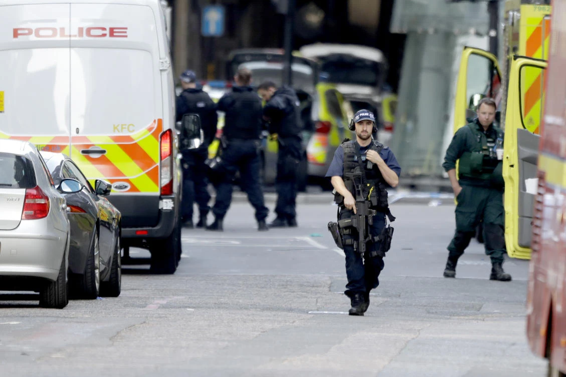 An armed British police officer walks within a cordoned off area after an attack in the London Bridge area of London, Sunday, June 4, 2017. (AP)