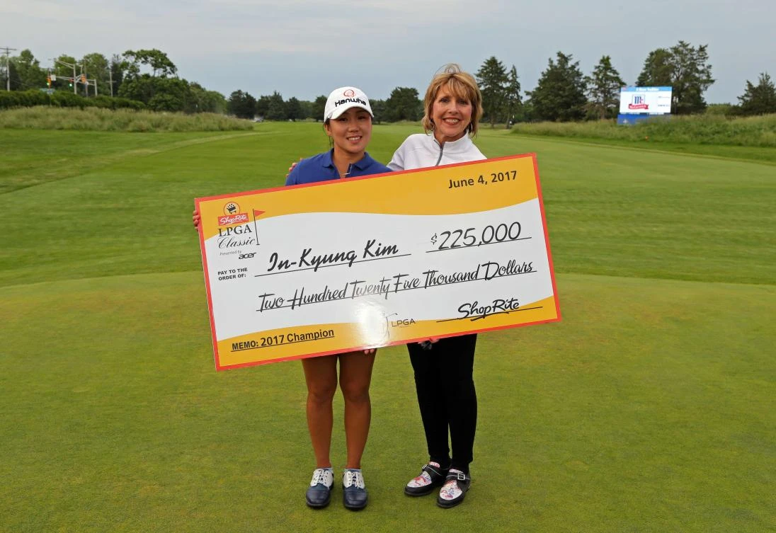 In-Kyung Kim of South Korea is presented the winner's check by Wakefern Food Corp. VP of Social Media, Digital Advertising and Content Creation, Karen Gozzi, after winning the ShopRite LPGA Classic presented by Acer on the Bay Course at Stockton Seaview Hotel & Golf Club on Sunday in Galloway, New Jersey. (AFP)