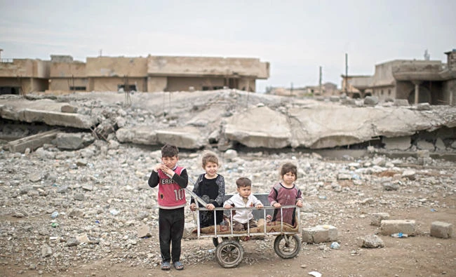 Children pose from a site recently retaken by Iraqi security forces from Daesh militants in Mosul. (AP)