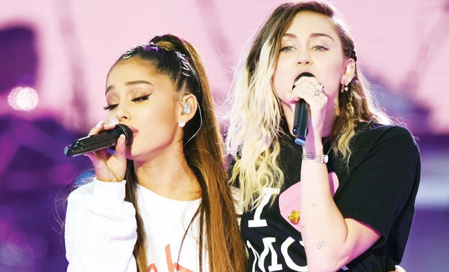 Singers Ariana Grande, left, and Miley Cyrus perform at the One Love Manchester tribute concert in Manchester, north western England, Sunday. (AP)
