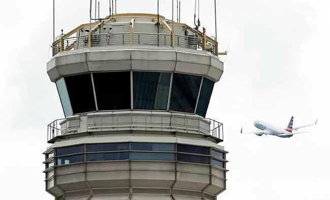 A plane passes the air traffic control tower at Ronald Reagan Washington National Airport in Arlington, Virginia, U.S., on Monday. (REUTERS)