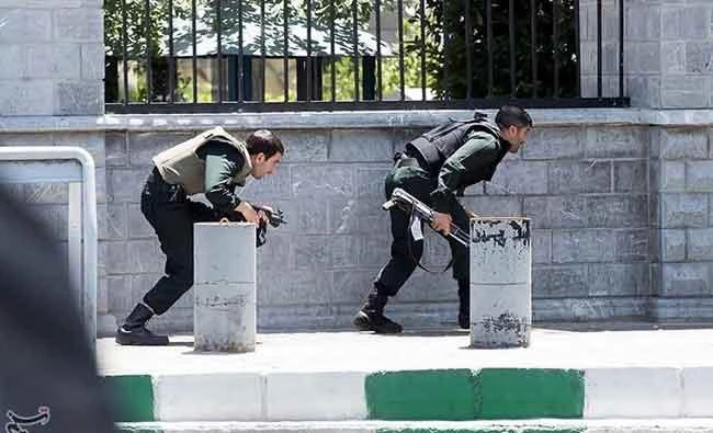 Members of Iranian forces take cover during an attack on the Iranian parliament in central Tehran, Iran, on Wednesday. (REUTERS)