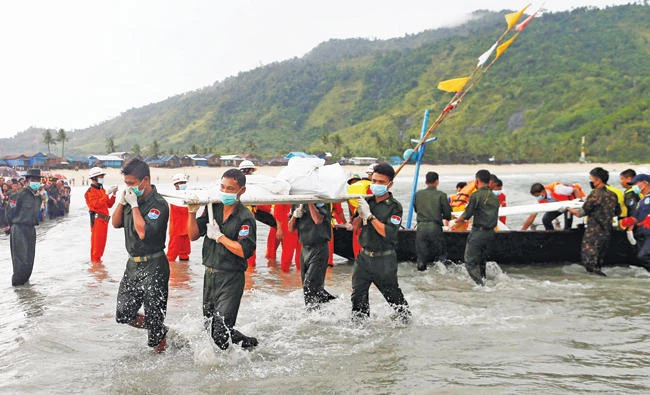 Soldiers carry bodies from a crashed military plane outside Launglon township, Myanmar on Thursday. (Reuters)