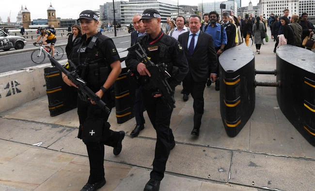 Armed police officers walk past newly installed barriers on London Bridge in London Thursday, following the June 3 terror attack that targeted members of the public on London Bridge and Borough Market. (AFP)