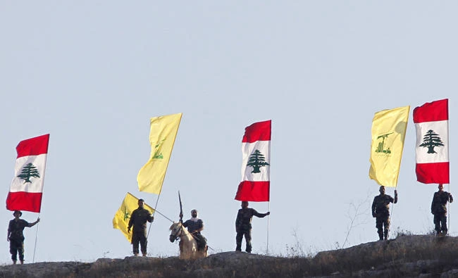Members of Lebanon's Hezbollah wave Hezbollah and Lebanese flags in Wadi al-Hujeir, southern Lebanon in this August 14, 2015 photo. Two naturalized Americans from New York and Michigan have been charged with terrorism for operating on behalf of Shiite militant group Hezbollah. (REUTERS/Aziz Taher/File Photo)