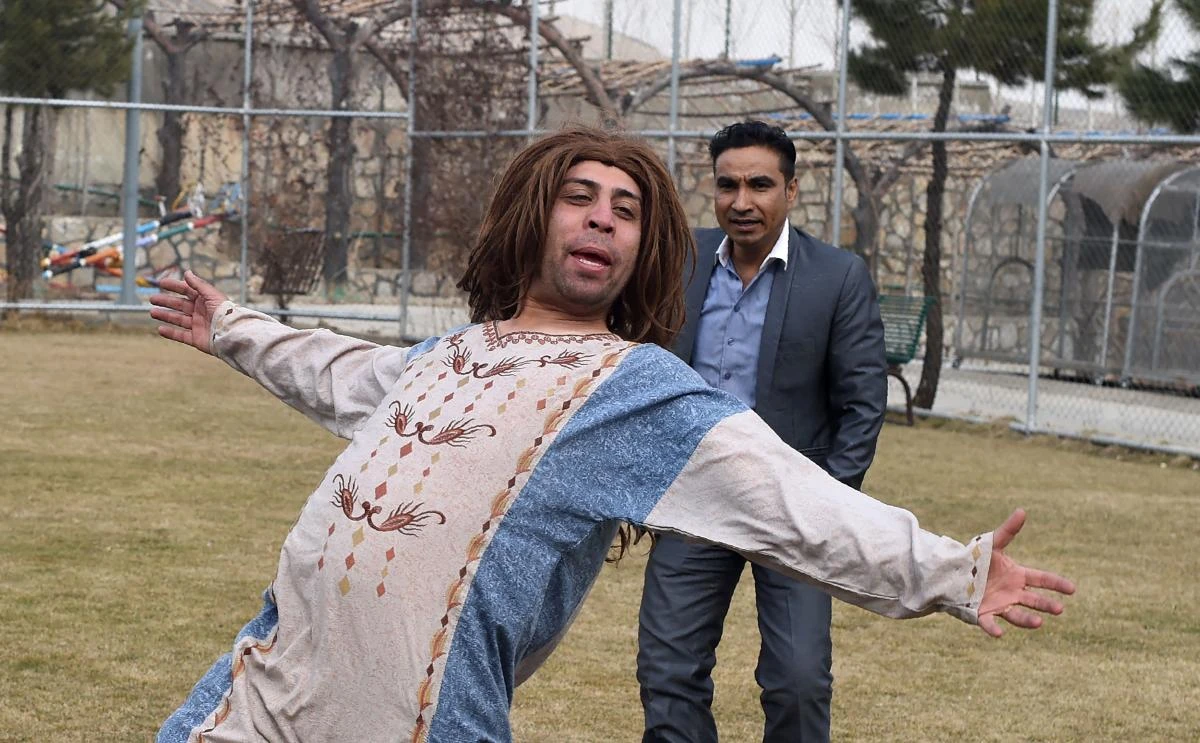 In this photograph taken on March 6, 2017, Afghan comedian Ibrahim Abed (R) and Ahmad Siar Matin perform humourous songs while filming a scene for the comedy television show Shabak-e-Khanda on the outskirts of Kabul. (AFP)
