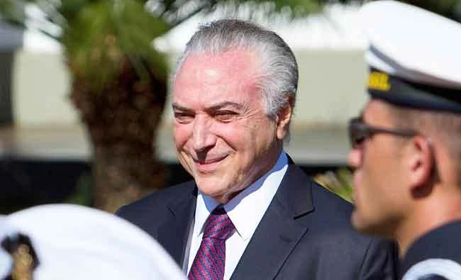Brazil's President Michel Temer smiles as he receives military honors during ceremony, in Brasilia, Brazil, on Friday. (AP)