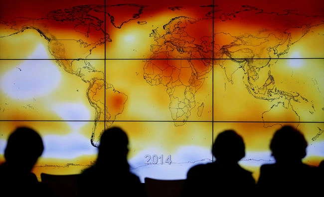 Participants are seen in silhouette as they look at a screen showing a world map with climate anomalies during the World Climate Change Conference 2015 (COP21) at Le Bourget, near Paris, France, on December 8, 2015. (REUTERS/Stephane Mahe/File Photo)
