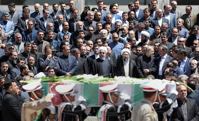 A handout picture provided by the Iranian Presidency on June 9, 2017 shows (C to R) Iran's President Hassan Rouhani, parliament speaker Ali Larijani and judiciary chief Sadeq Larijani attending the funeral of the victims of twin attacks in Tehran earlier in the week. (AFP)