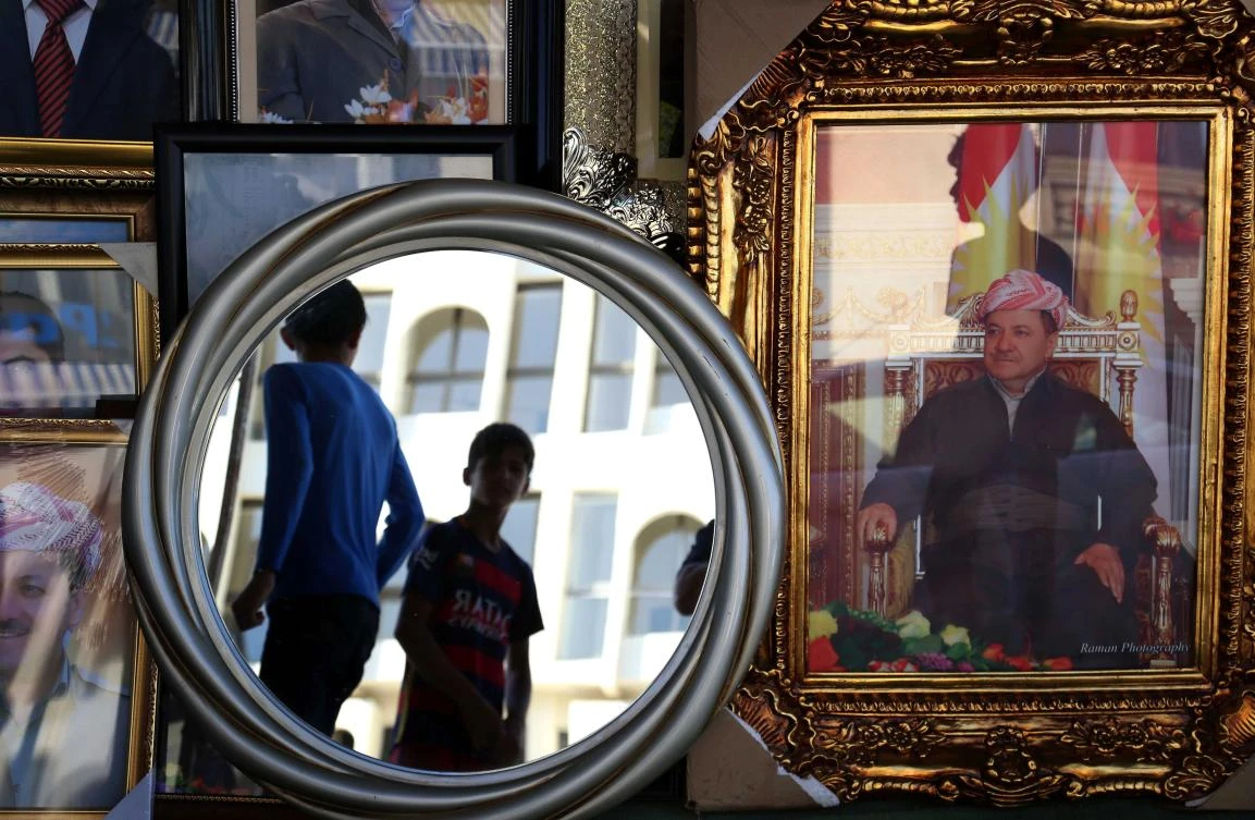 Portraits of Iraqi Kurdish leader Massud Barzani are seen hanging in a store, in Erbil. (AFP)