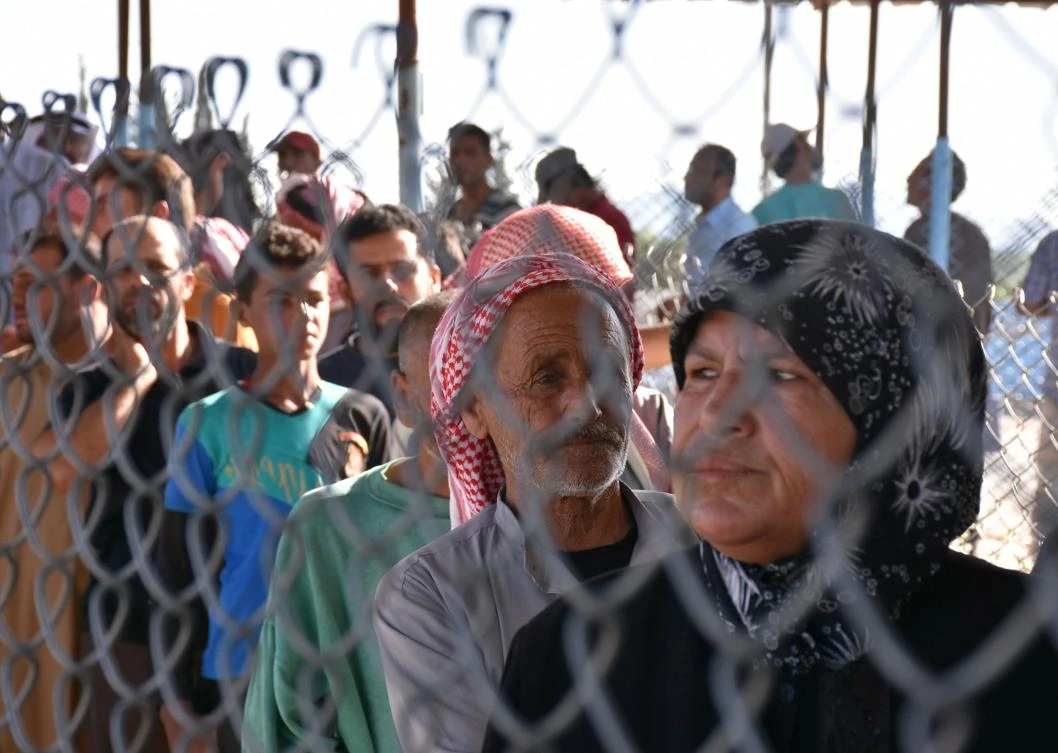 Displaced Syrians queue at a Kurdish controlled checkpoint between the opposition-held town of Azaz in northern Syria and the city of Afrin, along Syria's northern border with Turkey, as they attempt to cross on Friday. (AFP)