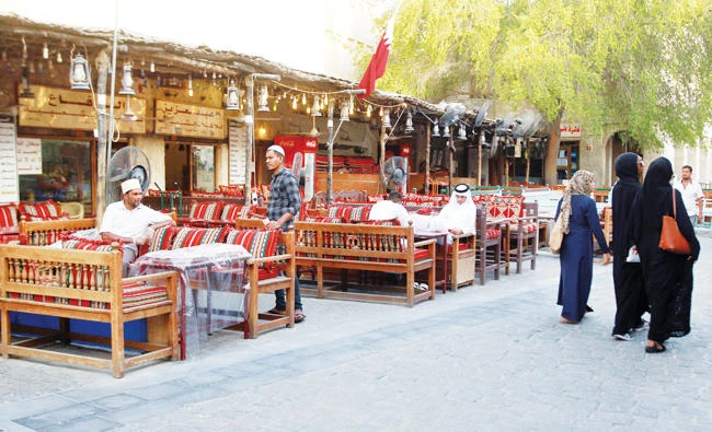 Women walk past men at Souq Waqif market in Doha. (Reuters)