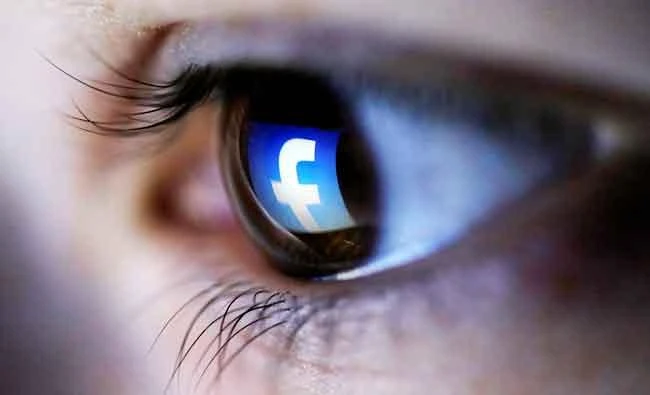 A photo illustration shows a Facebook logo reflected in a person's eye, in Zenica, in this file photo. (Reuters)