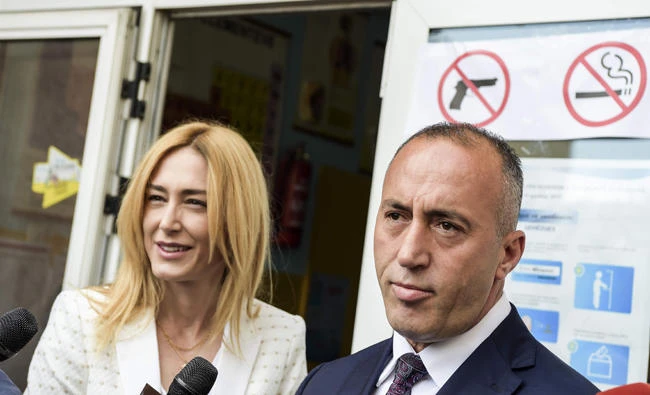Ramush Haradinaj, prime minister candidate and leader of the Alliance for Future of Kosovo (AAK), speaks to the press next to his wife Anita after voting at a polling station in Pristina on Sunday. (AFP)