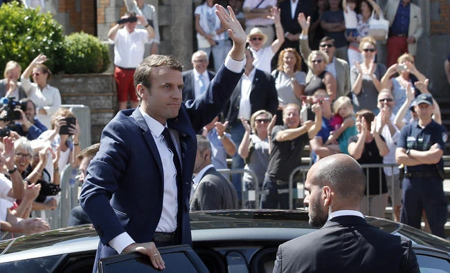French President Emmanuel Macron waves to the audience as he leaves a polling station in Le Touquet, northern France, after casting his vote in the first round of the two-stage legislative elections on Sunday. (AP Photo/Thibault Camus)
