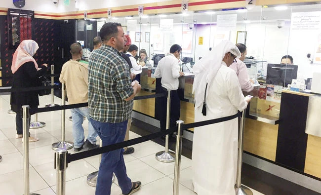 People exchange money at a financial firm in Doha, Qatar. (Reuters)