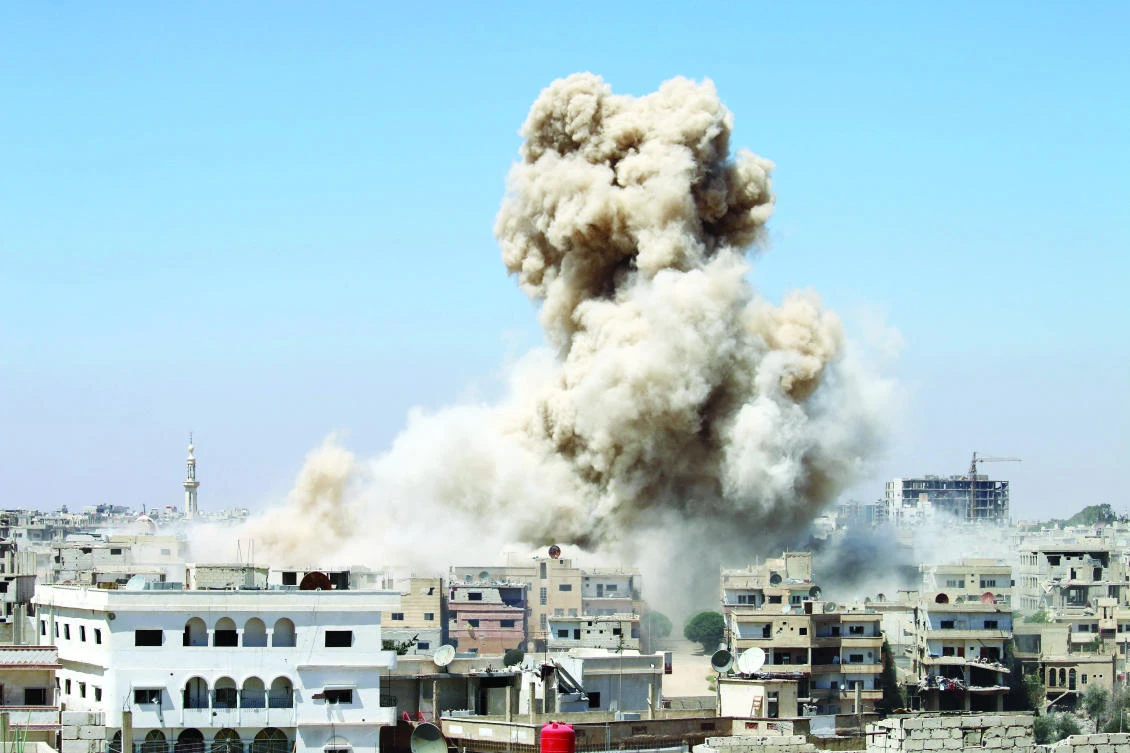 Smoke rises from buildings following a reported airstrike on an opposition-held area in the southern Syrian city of Daraa, on Wedensday. (AFP)