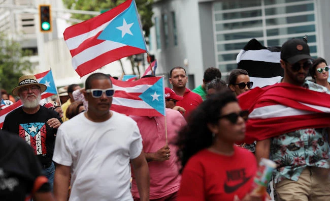 People march in support of Puerto Rico becoming an independent nation as the economically struggling U.S. island territory voted overwhelmingly on Sunday in favour of becoming the 51st state, in San Juan, Puerto Rico. (REUTERS/Alvin Baez)
