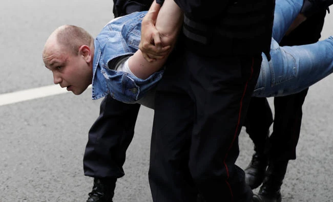 A demonstrator is detained by riot police during an anti-corruption protest organized by opposition leader Alexei Navalny, on Tverskaya Street in central Moscow, Russia, on Monday. (REUTERS/Tatyana Makeyeva)