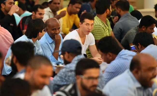Muslims break fast at an "Iftar" outside a mosque in the Dubai Marina neighborhood in this file photo. Qataris who are married to Emiratis have been exempted from an order expelling Qataris from the UAE. (AFP / GIUSEPPE CACACE)