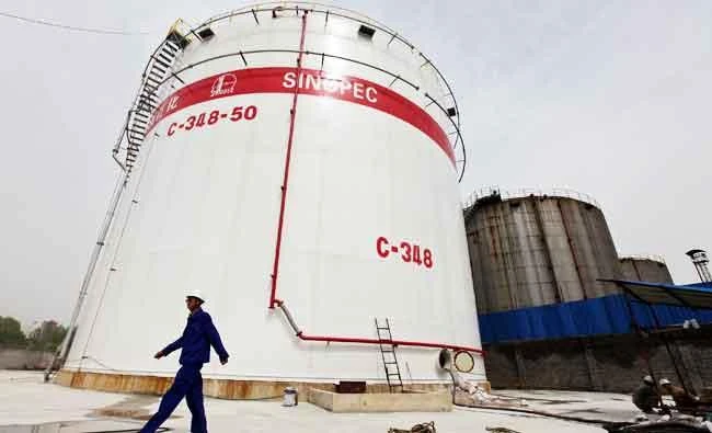 An employee walks past oil tanks at a Sinopec refinery in Wuhan, Hubei province, in this April 25, 2012 file photo. (REUTERS)
