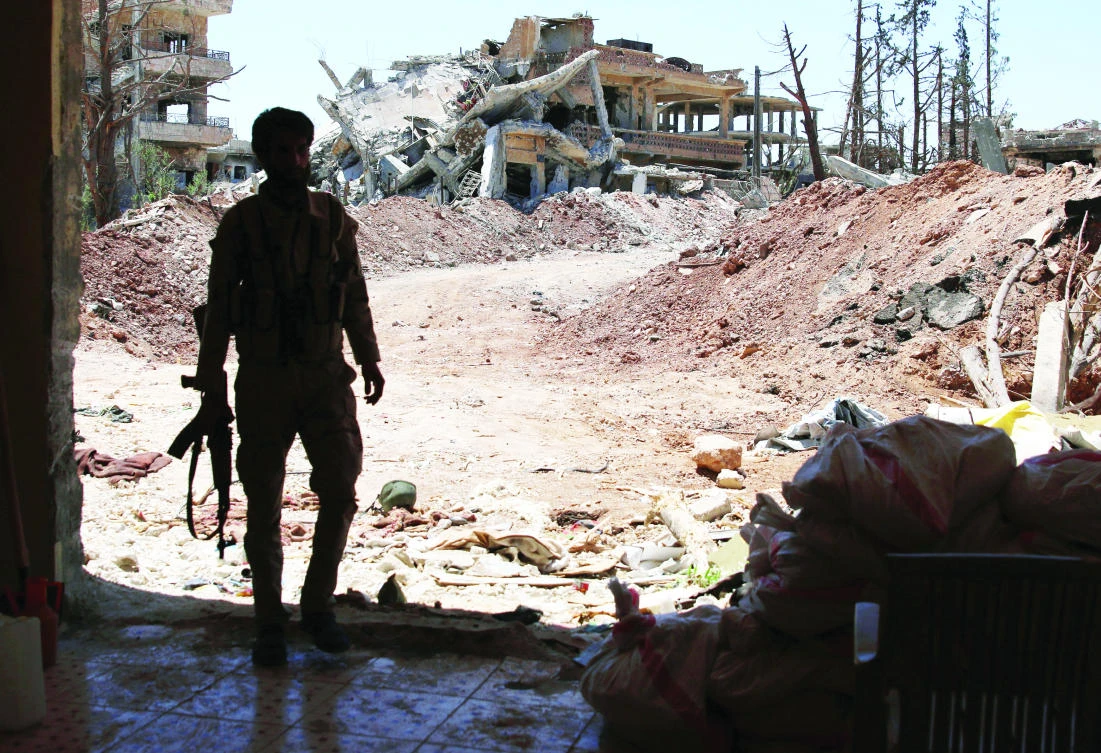 A Free Syrian Army fighter stands in the Manshiya neighborhood, a rebel-held part of the southern city of Daraa. (Reuters)