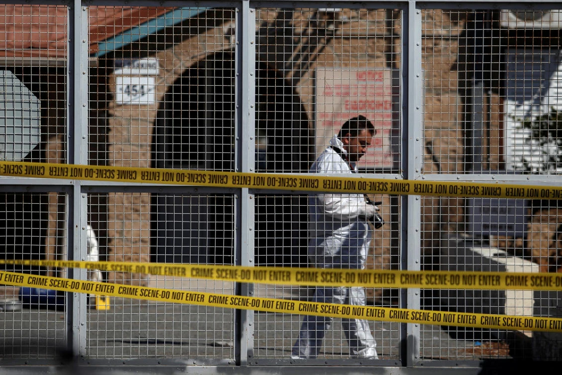 A forensic officer inspects the scene of a small explosion, outside a police station, in the British military base area of Dhekelia, Cyprus June 13, 2017. REUTERS/Yiannis Kourtoglou